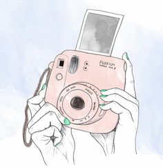 a woman holding up a pink camera to take a picture