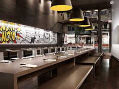 an empty restaurant with lots of tables and benches in front of the counter top area