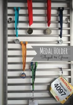 medal holders are hanging on the wall with ribbons attached to them and an ad for medals