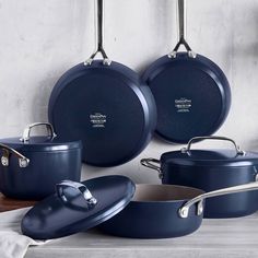 blue pots and pans are hanging on the wall