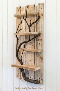 a wooden shelf with three shelves and a tree branch on it