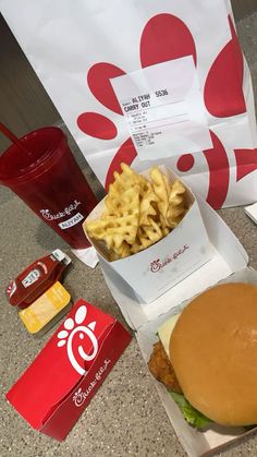 a hamburger and fries are sitting on the counter next to some sodas, ketchup, and mcdonald's