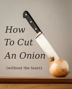 an onion being sliced on top of a table with a knife sticking out of it