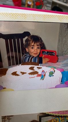 a young child sitting in front of a cake