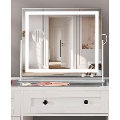 a white vanity with a large mirror on top of it and drawers underneath the mirror