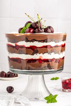 a layered cake with cherries and whipped cream