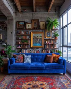 a blue couch sitting in front of a window next to a rug and bookshelf