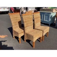 two chairs made out of wicker sitting next to each other in a parking lot