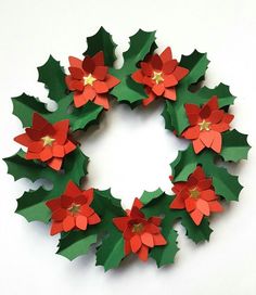 an origami christmas wreath with red and green paper flowers