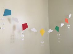 some paper kites are hanging on the wall next to each other in this room