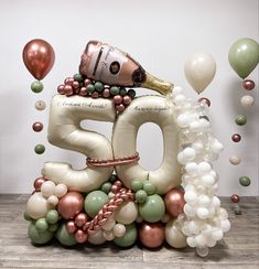 the balloon number 50 is surrounded by balloons and confetti as well as a bottle of champagne