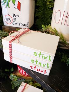 stack of christmas cards tied with twine on top of a table next to mugs