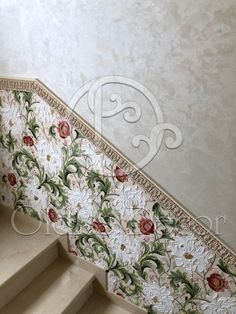 the stairs are decorated with floral wallpaper and gold trimmings, along with decorative carpeting