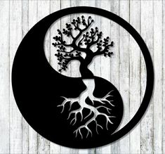 the yin symbol has a tree with roots growing out of it, on top of a wooden