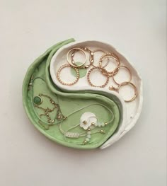 an assortment of rings and necklaces in a bowl