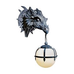 a metal dragon head hanging from the side of a light fixture on a white background