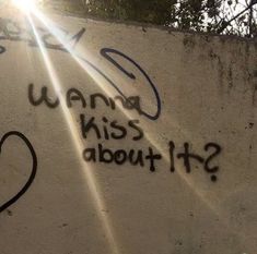 graffiti written on the side of a wall that says wannan't kiss about it?