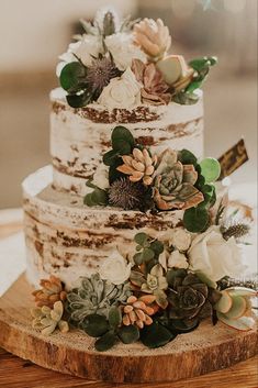 a three tiered wedding cake with succulents and flowers