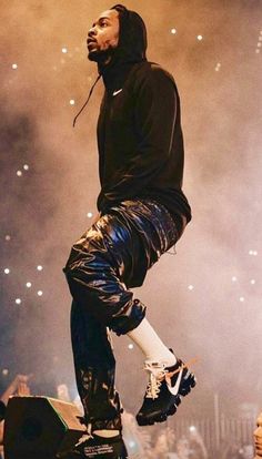 a man standing on top of a stage with his feet in the air