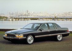 a black car parked in front of a body of water