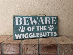 a wooden sign that says beware of the wigglebutts on it