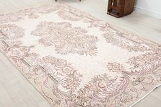 a large area rug in the middle of a room with wooden floors and white walls