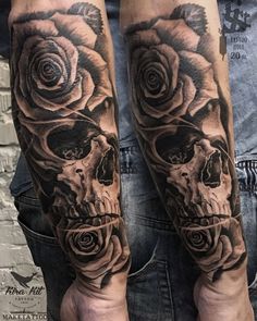 a man's arm with two skulls and roses on it