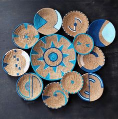 several woven baskets with blue and white designs are arranged on a black surface, top view