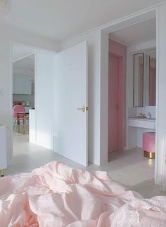 a bedroom with white walls and pink bedding