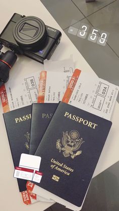 three passport cards and a camera on a table