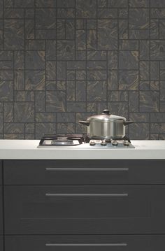 a stove top oven sitting next to a wall with a pot on the burner