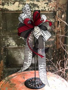 a black and white bow on top of an orange pumpkin