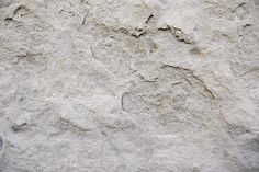 the texture of concrete is white and has small cracks in it, as well as some black dots