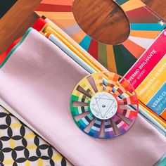 colorful items are sitting on top of each other in front of a wooden table with a circular object