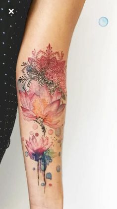 a woman's leg with flowers on it and watercolor paint splatters