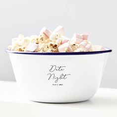 a bowl filled with marshmallows sitting on top of a white countertop