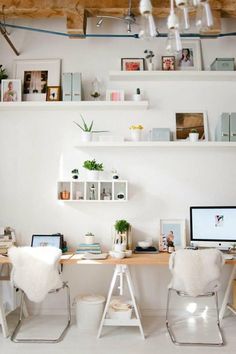 a white room with two computers on the desk