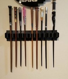 a wall mounted rack with several different types of pens and pencils hanging on it