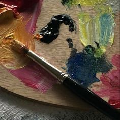 a paintbrush sitting on top of a wooden palette