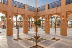 an indoor courtyard with fountain and palm trees