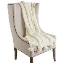 an upholstered chair with a white blanket on it's back and legs