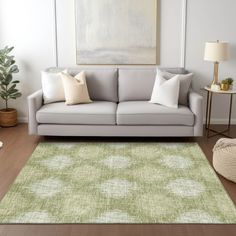 a living room scene with focus on the couch and rug in front of the sofa