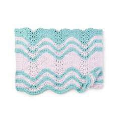 a blue and white crocheted blanket on top of a white surface with waves