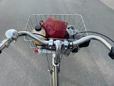 a basket on the handlebars of a bicycle with some items in it's basket