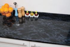 a bowl of fruit sitting on top of a black counter