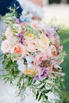 a bridal holding a bouquet of flowers and greenery