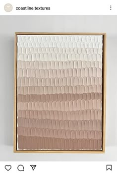 an art piece with pink and white paint on the bottom, in a wooden frame