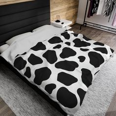 a bed with black and white cow print on it