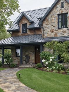 a large stone house with a metal roof