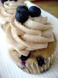 two cupcakes with white frosting and blueberries on top